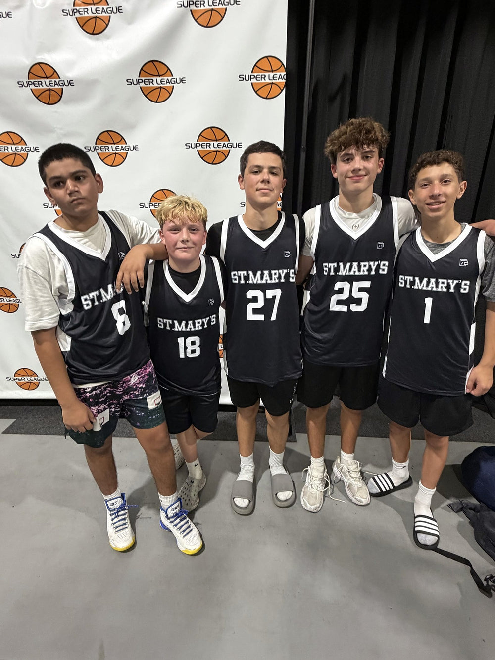 St. Mary's youth basketball players in custom black 7Bros jerseys at a Super League event