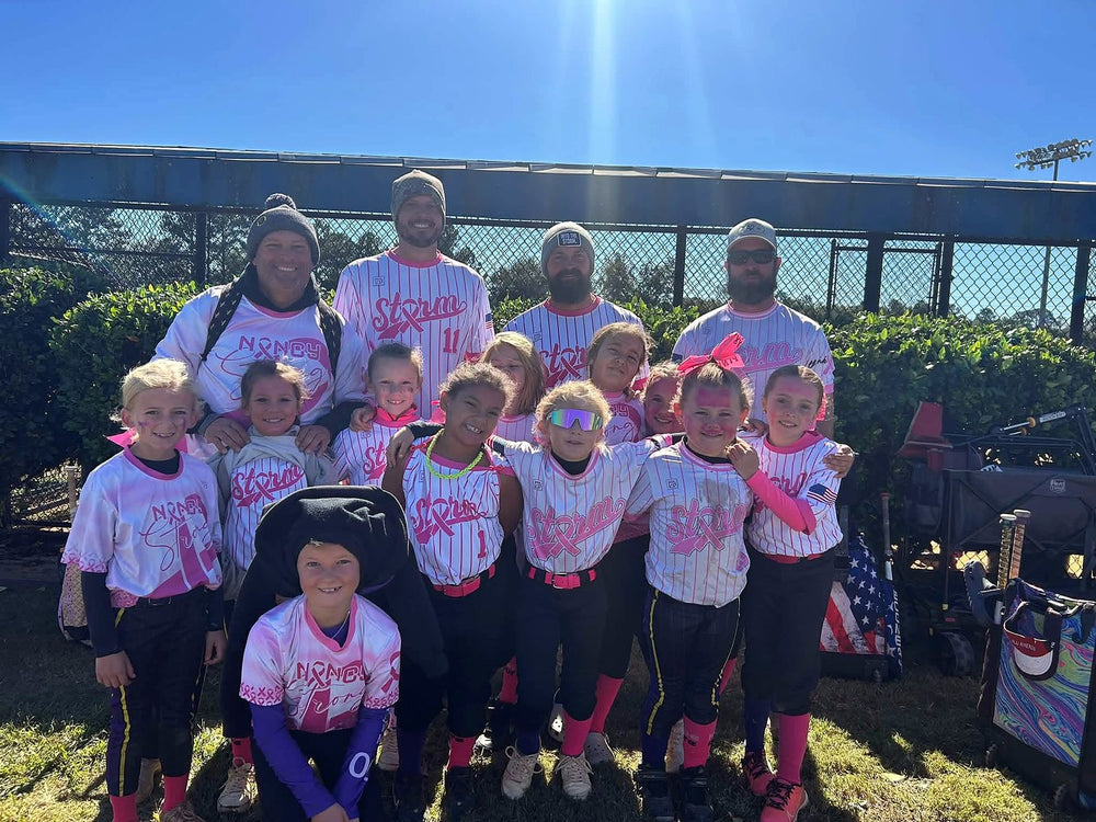 Saluda Storm youth softball team and coaches in custom pink pinstripe Nancy Strong breast cancer awareness jerseys